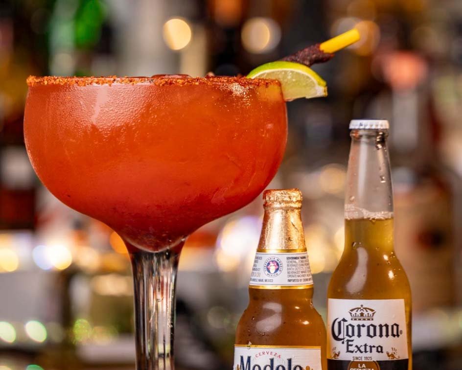 a cocktail drink with two beers on the side